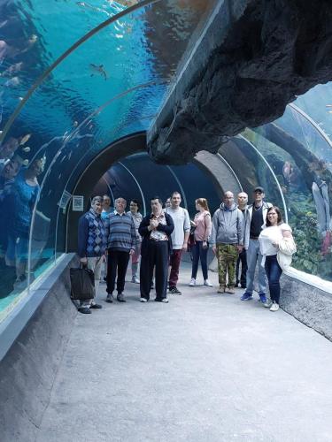 grupa ludzi stoi w tunelu akwariowym 